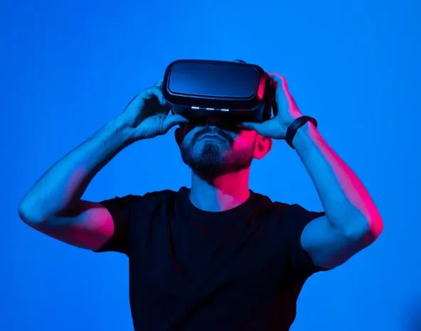 Bearded man in virtual reality headset communicate with a friends in a metaverse. Young man playing a vr video game.