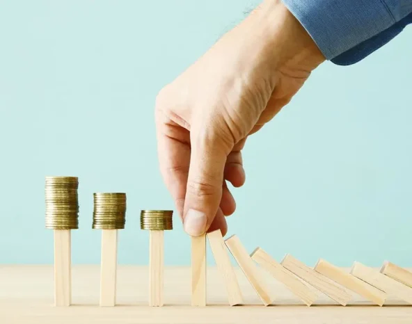 concept image of investing and banking. A businessman stops the domino effect from risking financial investment