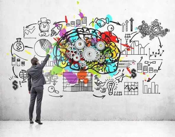 Rear view of a businessman in a suit drawing a brain sketch with gears on a concrete wall. There is also a startup drawing.